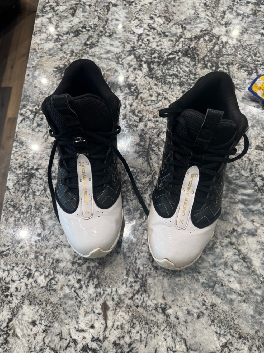 Under Armour Black and White Lace-Up Athletic Cleats with Gold Accent